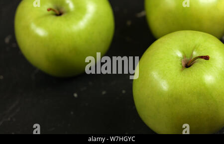 Nahaufnahme Foto, grüne Äpfel auf dem Schwarzen Brett. Stockfoto