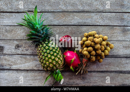 Close Up Mix Frucht von Reifen longans Ananas und Apfel auf einem alten hölzernen Hintergrund mit der Natur Licht Stockfoto