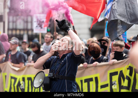 Anti-faschistischen Demonstranten in Opposition zur freien Tommy Robinson Protestkundgebung in London, UK. Leader singen in Megaphon. Rauch von flare Stockfoto