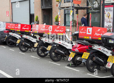 Eine Reihe von PIzza Hut Motorroller außerhalb eines seiner Geschäfte an der Fulham Road, Fulham, London, UK geparkt Stockfoto