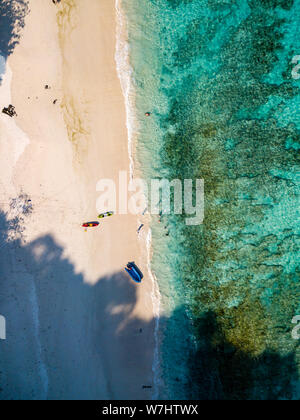 Antenne drone Ansicht von Touristen und Kajaks auf einer wunderschönen, unberührten tropischen Insel Strand von Korallenriff umgeben Stockfoto