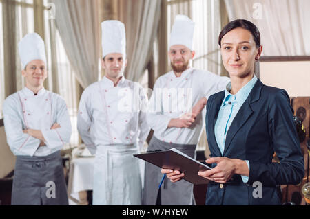 Restaurant Manager und sein Personal in küche. Interaktion Koch in der gewerblichen Küche zu Kopf Stockfoto