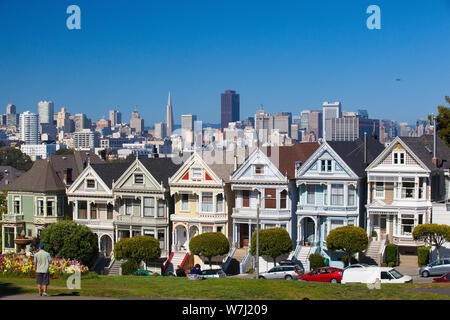 San Francisco, CA, USA - 20. Juli 2011: viktorianische Häuser in San Francisco mit der Innenstadt im Hintergrund. Blick vom Alamo Square bei Dämmerung, San Fran Stockfoto