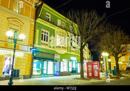 BAD ISCHL, Österreich - 26. FEBRUAR 2019: Die malerische beleuchtete Stadthäuser in den Kreuzplatz Platz mit Geschäften, Restaurants, Kunstgalerien und antiken sho Stockfoto