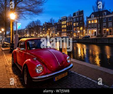 Alten VW Käfer Parks am Kanal, historische Häuserzeile an einem Kanal in der Dämmerung, Amsterdam, Nordholland, Niederlande Stockfoto