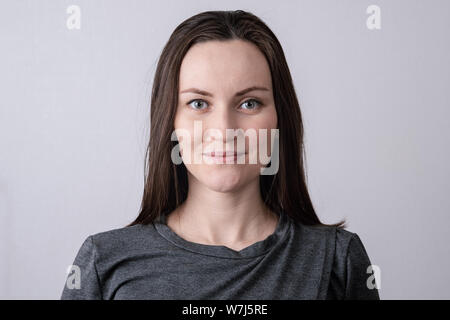 Authentische Porträt der jungen europäischen Frau, frontal vor der Kamera Stockfoto