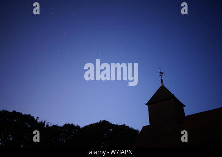 Harty, Kent, Großbritannien. 6. August 2019. UK Wetter: klarer Himmel bei Dämmerung über Harty in Kent. Im Bild: die Konstellation auf der linken Seite der Kirche des Hl. Apostels Thomas Harty Pflug. Credit: James Bell/Alamy leben Nachrichten Stockfoto