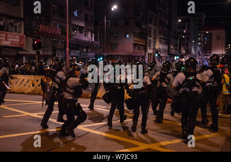 Riot Polizisten mit vollem Aufruhr Zahnräder rush Demonstranten zu konfrontieren. Tausende Demonstranten die Sham Shui Po Bezirk Polizei umgeben Station die Freigabe der Student Union Präsident Keith Fong Chung Yin, die für den Kauf einer Stichflamme Laser Pointer, das die Polizei es als Waffen in Betracht ziehen, die neuesten Auseinandersetzungen zwischen den Demonstranten und der Polizei verhaftet wurde, zu verlangen. Stockfoto