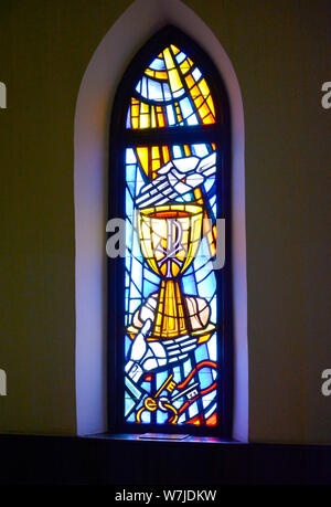 Ein wunderschönes Buntglasfenster in einem Bogenfenster des Heiligen Grals mit einer Tafel im Inneren des St. Peter's Episcopal Church in Oxford, MS, USA Stockfoto