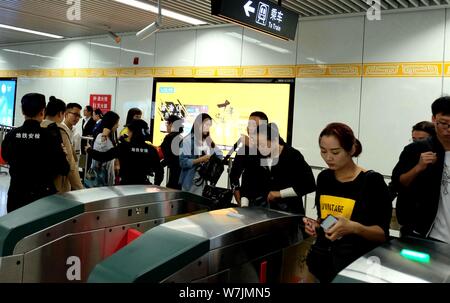 Passagiere throng durch Sicherheit prüfen, ob während der morgendlichen Rush hour an Nansanhuan Bahnhof zu gehen, um auf die Metro Linie 2 in Zhengzhou City, Central China provi Stockfoto