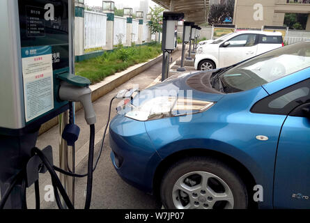 ---- Ein Elektrofahrzeug (EV) wird auf einen Stapel von der State Grid Corporation of China (SGCC) auf einem Parkplatz in Wuhan City, cen Stockfoto