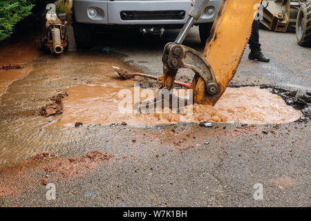 Splatter von Wasser von rohrbruch der Hauptstraße Auslaufen von Wasser aus der Bohrung Stockfoto