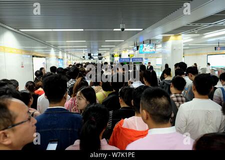 Passagiere throng durch Sicherheit prüfen, ob während der morgendlichen Rush hour an Nansanhuan Bahnhof zu gehen, um auf die Metro Linie 2 in Zhengzhou City, Central China provi Stockfoto