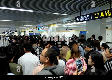 Passagiere throng durch Sicherheit prüfen, ob während der morgendlichen Rush hour an Nansanhuan Bahnhof zu gehen, um auf die Metro Linie 2 in Zhengzhou City, Central China provi Stockfoto