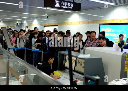 Passagiere throng durch Sicherheit prüfen, ob während der morgendlichen Rush hour an Nansanhuan Bahnhof zu gehen, um auf die Metro Linie 2 in Zhengzhou City, Central China provi Stockfoto