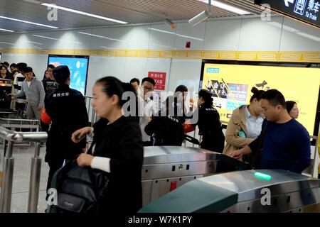 Passagiere throng durch Sicherheit prüfen, ob während der morgendlichen Rush hour an Nansanhuan Bahnhof zu gehen, um auf die Metro Linie 2 in Zhengzhou City, Central China provi Stockfoto