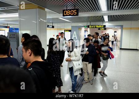 Passagiere throng durch Sicherheit prüfen, ob während der morgendlichen Rush hour an Nansanhuan Bahnhof zu gehen, um auf die Metro Linie 2 in Zhengzhou City, Central China provi Stockfoto