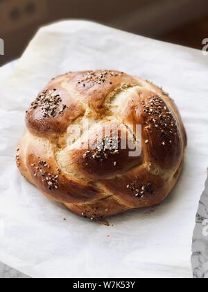 Runde challah geflochtener Brot hausgemachte gebackene auf Trägerfolie traditionelle jüdische Speisen für Schabbat und Feiertage Stockfoto