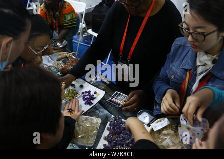 ---- Besucher drängen sich Kristalle am Stand von drei kenianischen Frauen während einer Messe in Changchun Stadt zu kaufen, im Nordosten Chinas in der Provinz Jilin, 2 Stockfoto