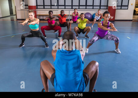 Männliche Trainer Ausbildung Yoga im Fitnesscenter durchführen Stockfoto