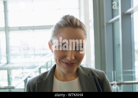 Happy Geschäftsfrau, die in der Flur am Büro Stockfoto