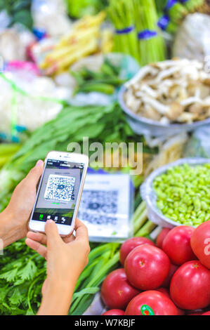 --FILE - ein Kunde scannt einen QR-Code über Mobile Payment Service Alipay von Alibaba Group auf seinem Smartphone für seinen Kauf auf einem Markt in Peking zu zahlen Stockfoto