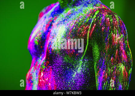 Konzept. Portrait eines bärtigen Mannes. Der Mann ist in UV-Pulver lackiert Stockfoto