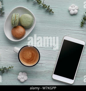 Frühling flach mit Kaffee, Macarons, pearl Hyazinthen Blumen, Eukalyptus, Mobiltelefon und Geschenk Postkarten, square Zusammensetzung Stockfoto