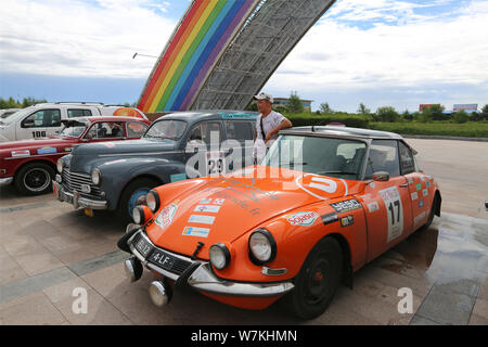 Ein anwohner Posen für Fotos mit Oldtimern in Erenhot City, North China Autonome Region Innere Mongolei, den 8. August 2017. Oldtimer arr Stockfoto