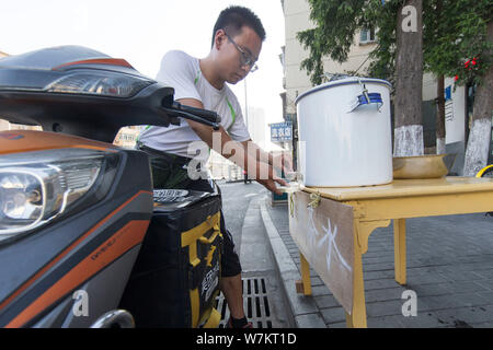 ---- Ein Radler trinkt das Wasser von den Chinesischen ältere Frau Cui Chuanmian an Passanten angeboten - von in Nanjing, Provinz Jiangsu, China 2. Stockfoto