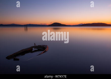 Eine fast vollständig versenkt kleines Boot in See Trasimeno (Umbrien, Italien) in der Dämmerung Stockfoto