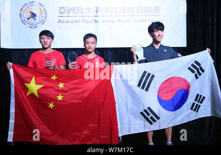 Cen Xiaolin, ein 13-jähriger Junge aus dem Süden Chinas Guangdong, Mitte, seine Trophäe und die Flagge der Volksrepublik China nach Posen Stockfoto