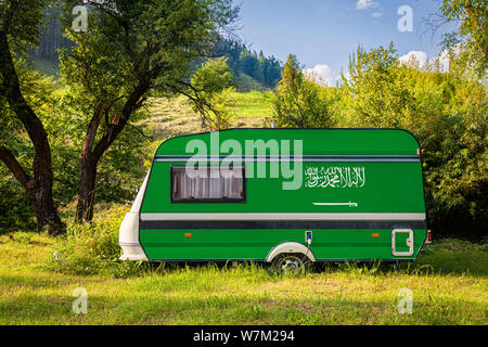 Ein PKW-Anhänger, Wohnmobil, in der nationalen Flagge Saudi-arabien lackiert steht in einer bergigen geparkt. Das Konzept des Straßenverkehrs, der Handel, Export Stockfoto