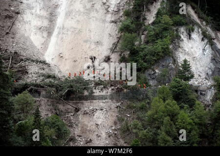 Chinesische Retter Spaziergang auf einem beschädigten Cliff Road für die Opfer und Überlebenden in der Jiuzhaigou Valley auf der Suche nach dem 7,0-Erdbeben in Jiuzh Stockfoto