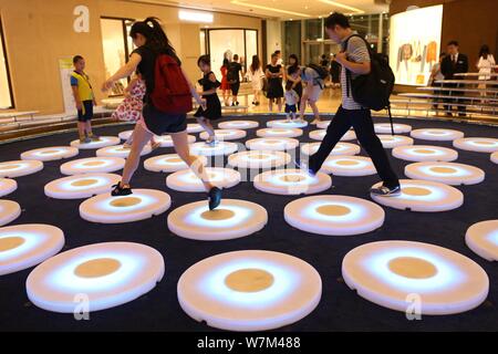 Besucher Schritt auf ein Brüllen pads Interaktiv - Licht Projekt' 'Pool'', Skulptur Künstler Jen Lewin erstellt, an Jing An Kerry Centre in Sh Stockfoto