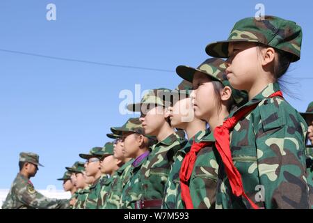 Primäre Schüler nehmen Teil an eine militärische Ausbildung an einer Schule, die zu Beginn des Semesters in Altay Präfektur, Xinjiang der Uiguren im Nordwesten Chinas Stockfoto