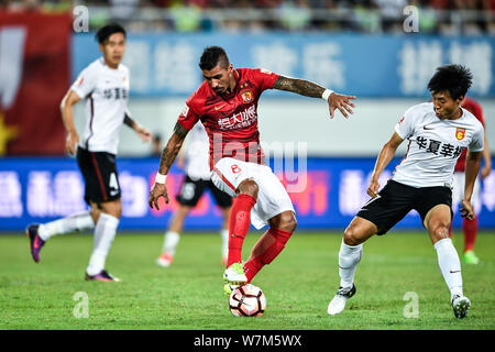 ---- Brasilianischen Fußballspieler Paulinho, links, von Guangzhou Evergrande kickt den Ball einen Pass gegen einen Spieler von Hebei China Fortune zu machen, der in der Stockfoto