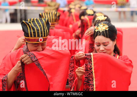 Paare der Jungvermählten im traditionellen Han Kostüme gekleidet werden, nehmen an einem Han-Stil Gruppe Trauung vor der Qixi Festival, auch als bekannt Stockfoto