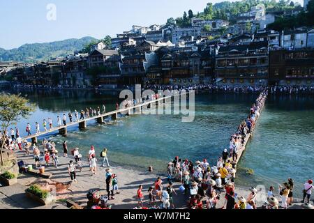 Touristen gehen Sie zu Fuß steht die Tuo Tuojiang River (Fluss) in der Alten Stadt Fenghuang Scenic Area in Fenghuang Grafschaft zu Kreuz, Xiangxi Tujia und Stockfoto