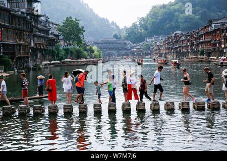 Touristen gehen Sie zu Fuß steht die Tuo Tuojiang River (Fluss) in der Alten Stadt Fenghuang Scenic Area in Fenghuang Grafschaft zu Kreuz, Xiangxi Tujia und Stockfoto