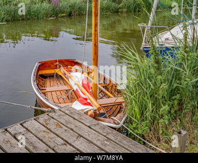 Eine kleine hölzerne Beiboot bis zu einer hölzernen Kai Position auf dem Fluss Bure in den Norfolk Broads günstig Stockfoto