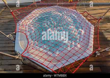 Runde Outdoor Whirlpool Jacuzzi mit sprudelndem Wasser auf dem Deck eines Kreuzfahrtschiffes. Geschlossen mit einem Netz für die Nacht. Blick von oben. Stockfoto