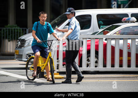---- Ein Polizist stoppt einen Radfahrer Fahrrad der Chinesischen bike-sharing Service ofo in Shenzhen, der südchinesischen Provinz Guangdong, 27 J Stockfoto