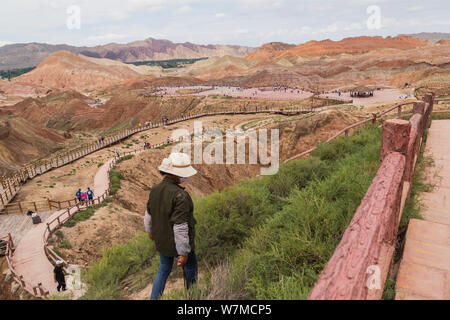 49-jährige Chinesische cleaner Zunamen Hu Müll sammelt auf einem steilen Berg an der Zhangye Danxia Relief geologischen Park in Zhangye Stadt, Nordwesten Stockfoto