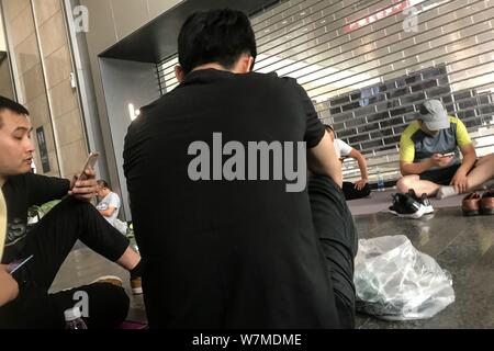 Debt Collectors einschließlich einigen seiner Lieferanten aus der ganzen Grafschaft liegen oder auf Decken und Yogamatten sitzen an der auf der Pekinger Zentrale der Ch Stockfoto