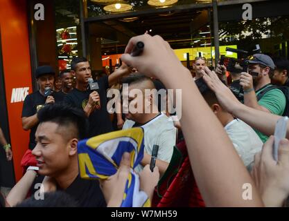 Portugiesische Fußballspieler Cristiano Ronaldo von Real Madrid wird von Fans bei einem Fan Meeting Ereignis an einem Nike Sportswear Store in Shanghai, C umgeben Stockfoto