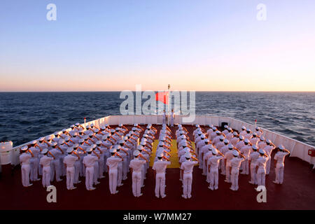 Chinesische PLA (Volksbefreiungsarmee) Soldaten salute während der Flagge - Anhebung Zeremonie an Dalian Maritime University Training Schiff Changsha liegt an Stockfoto