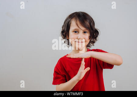 Lächelnd kleiner Junge macht eine Pause oder Pause Zeit Geste Stockfoto