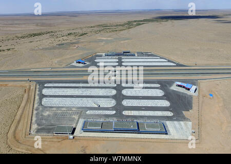 Luftaufnahme des Beijing-Urumqi Expressway, gemeinhin als Jingxin Expressway bekannt, durch die Wüste Gobi in Jiuquan Stadt im Nordwesten Chinas Gan Stockfoto