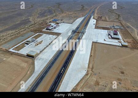 Luftaufnahme des Beijing-Urumqi Expressway, gemeinhin als Jingxin Expressway bekannt, durch die Wüste Gobi in Jiuquan Stadt im Nordwesten Chinas Gan Stockfoto